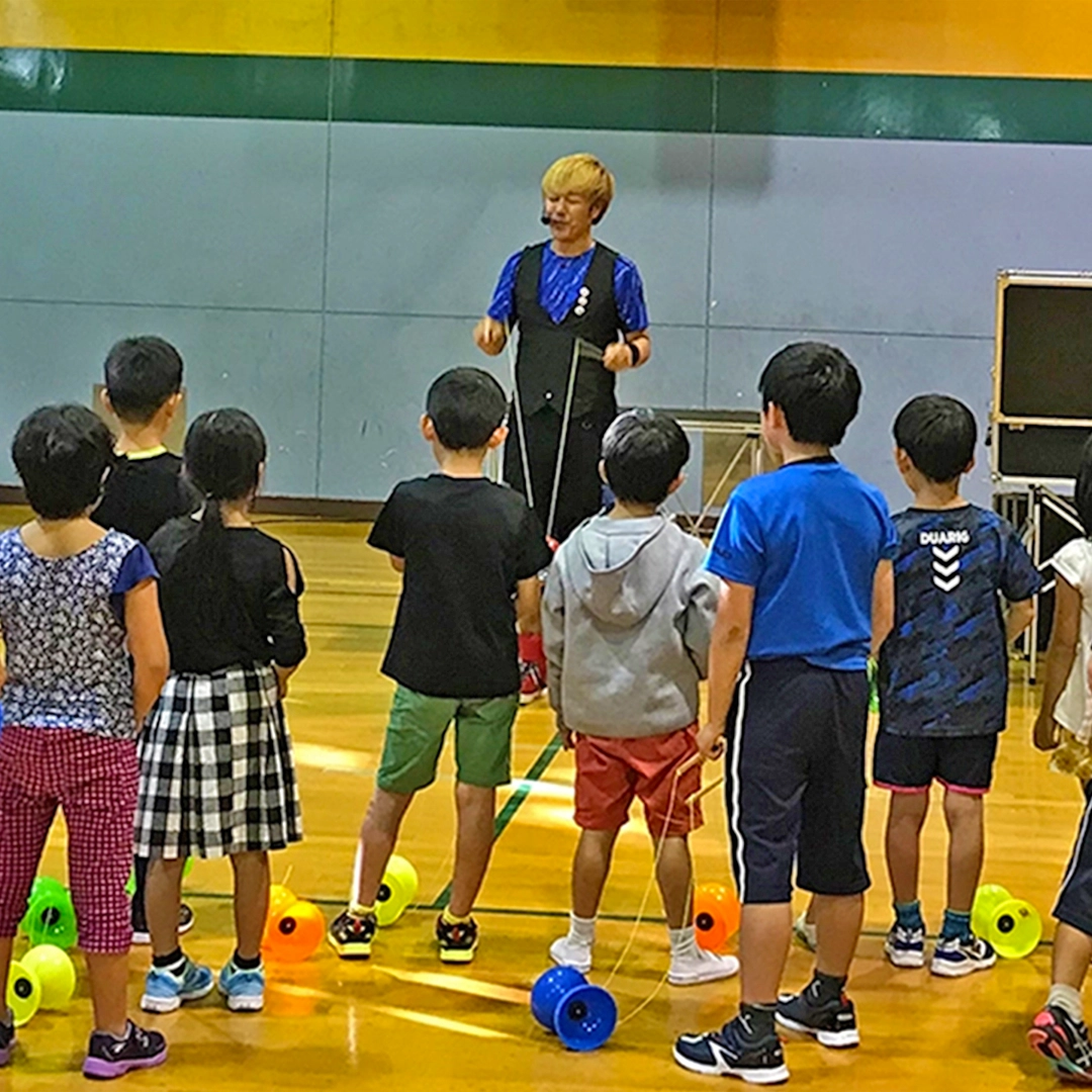 ディアボロレッスンで子どもたちに指導するYu-kiの写真