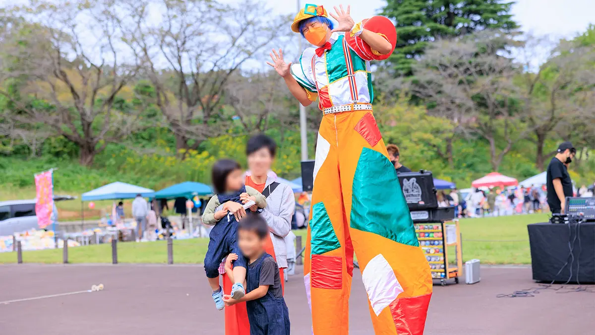 スティルトを装着した足長ゆうきが来場者と交流する会場内グリーティングの様子