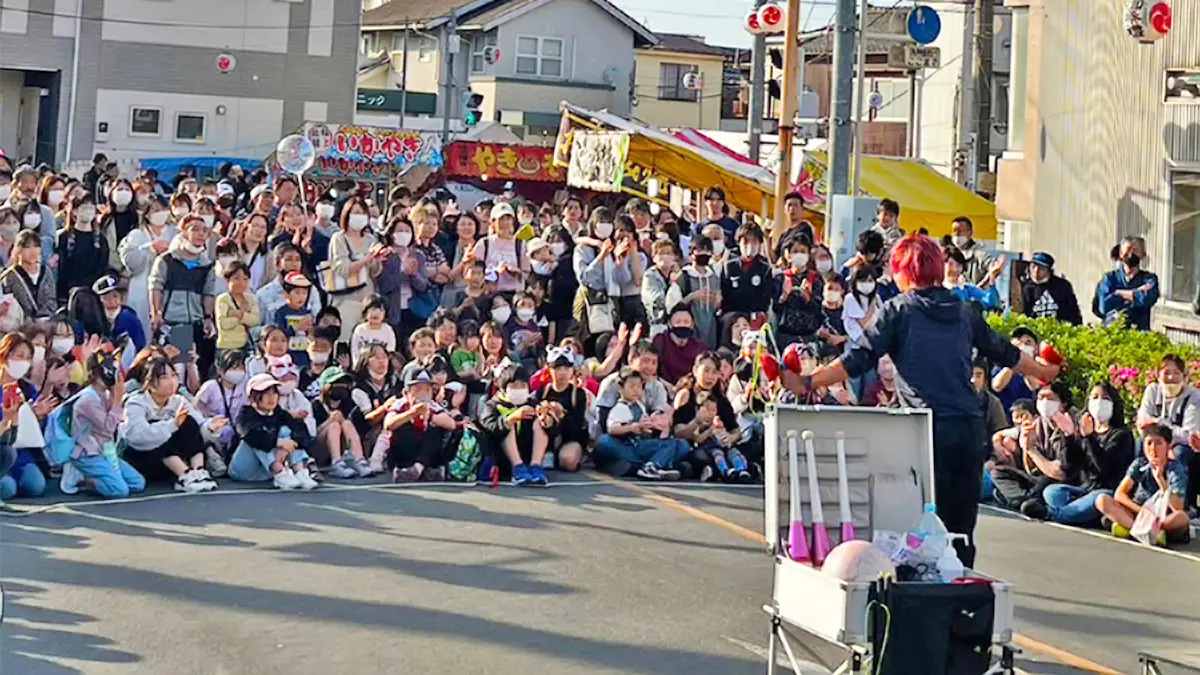 屋外イベントで観客に囲まれながら大道芸パフォーマンスを披露するPerformer Yu-ki